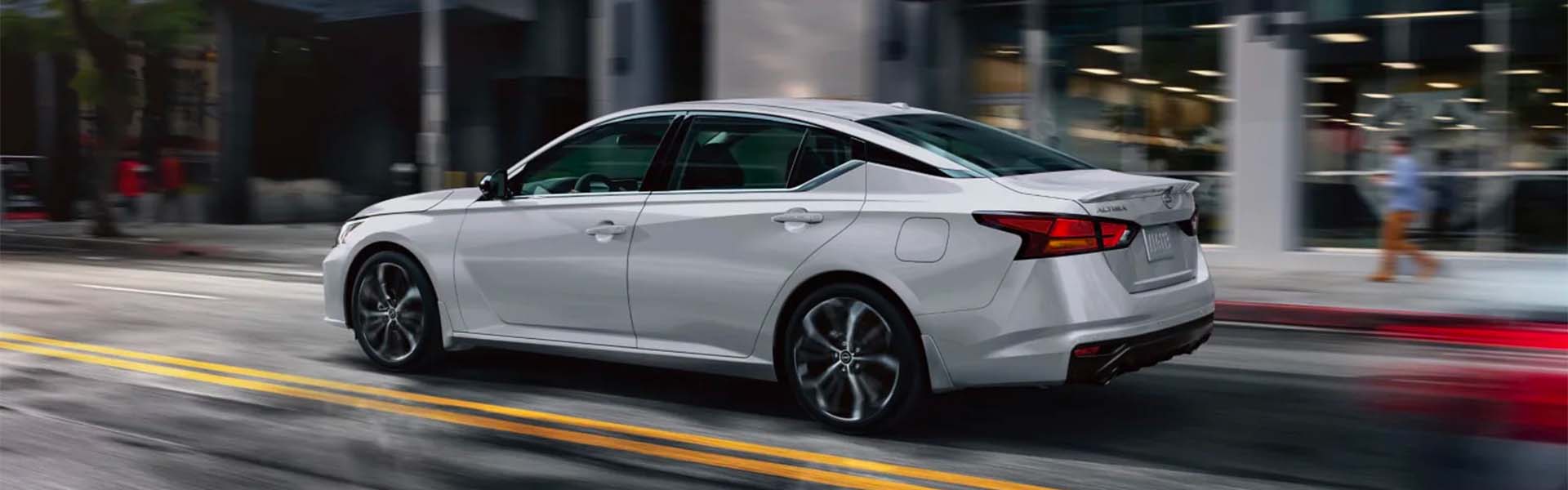 A white car driving on the road.
