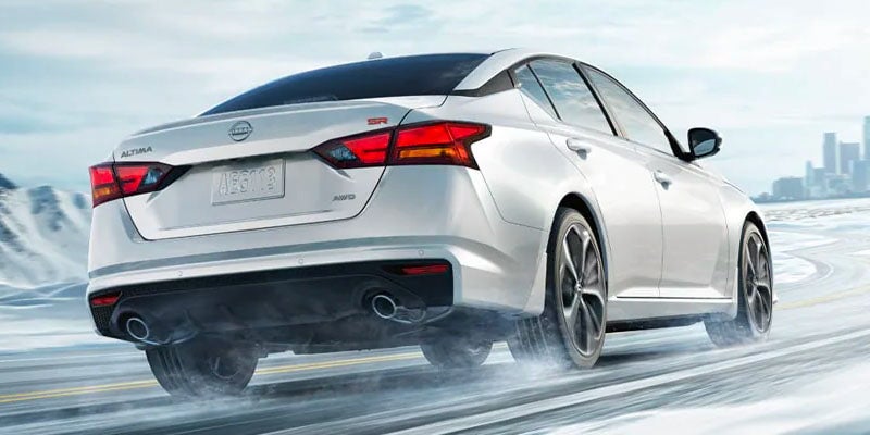 A white car driving on the road.