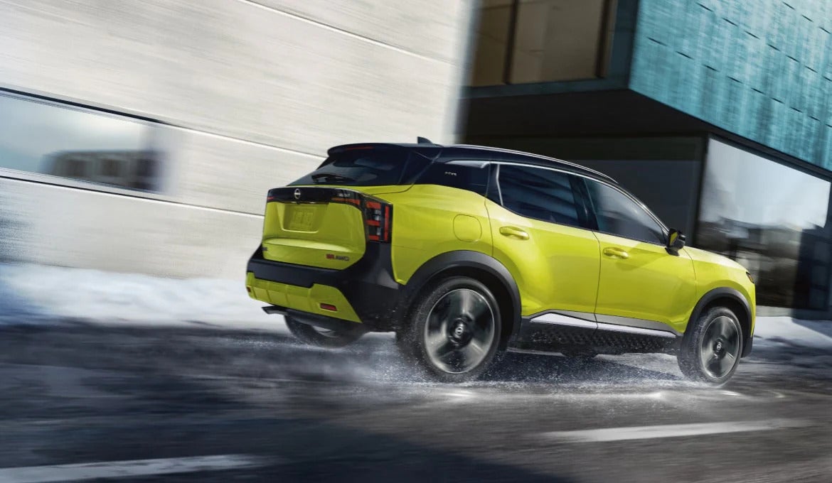 a yellow compact suv driving in the snow