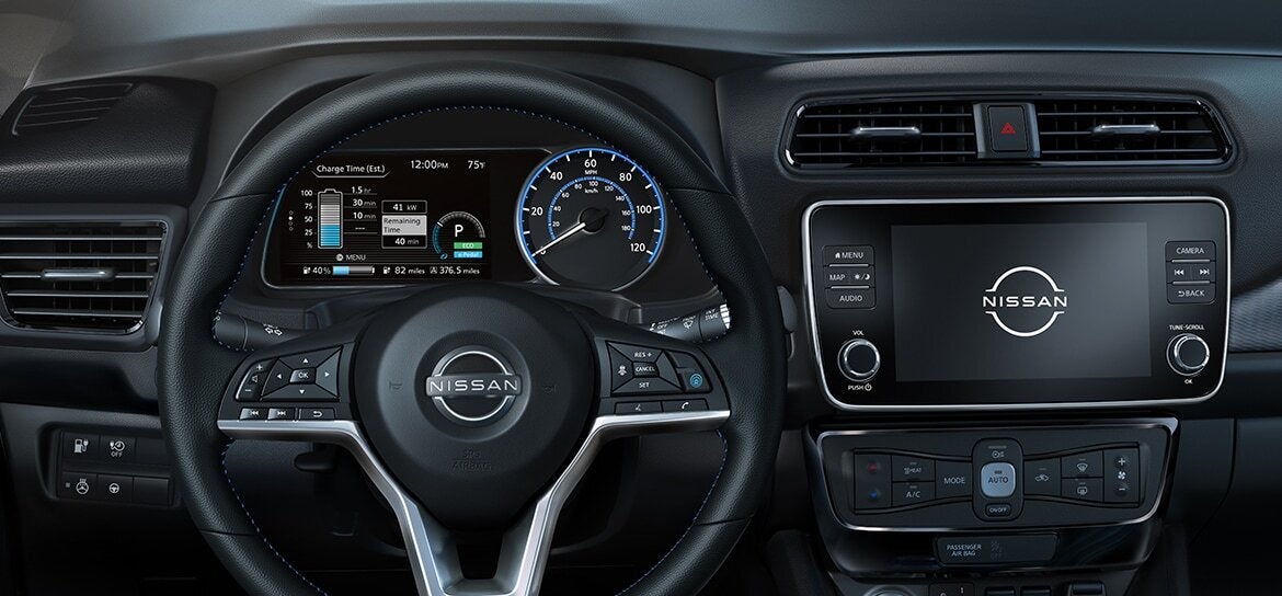 Close-up of the 2025 Nissan Leaf steering wheel and instrument panel, displaying the vehicle's digital speedometer and battery status.