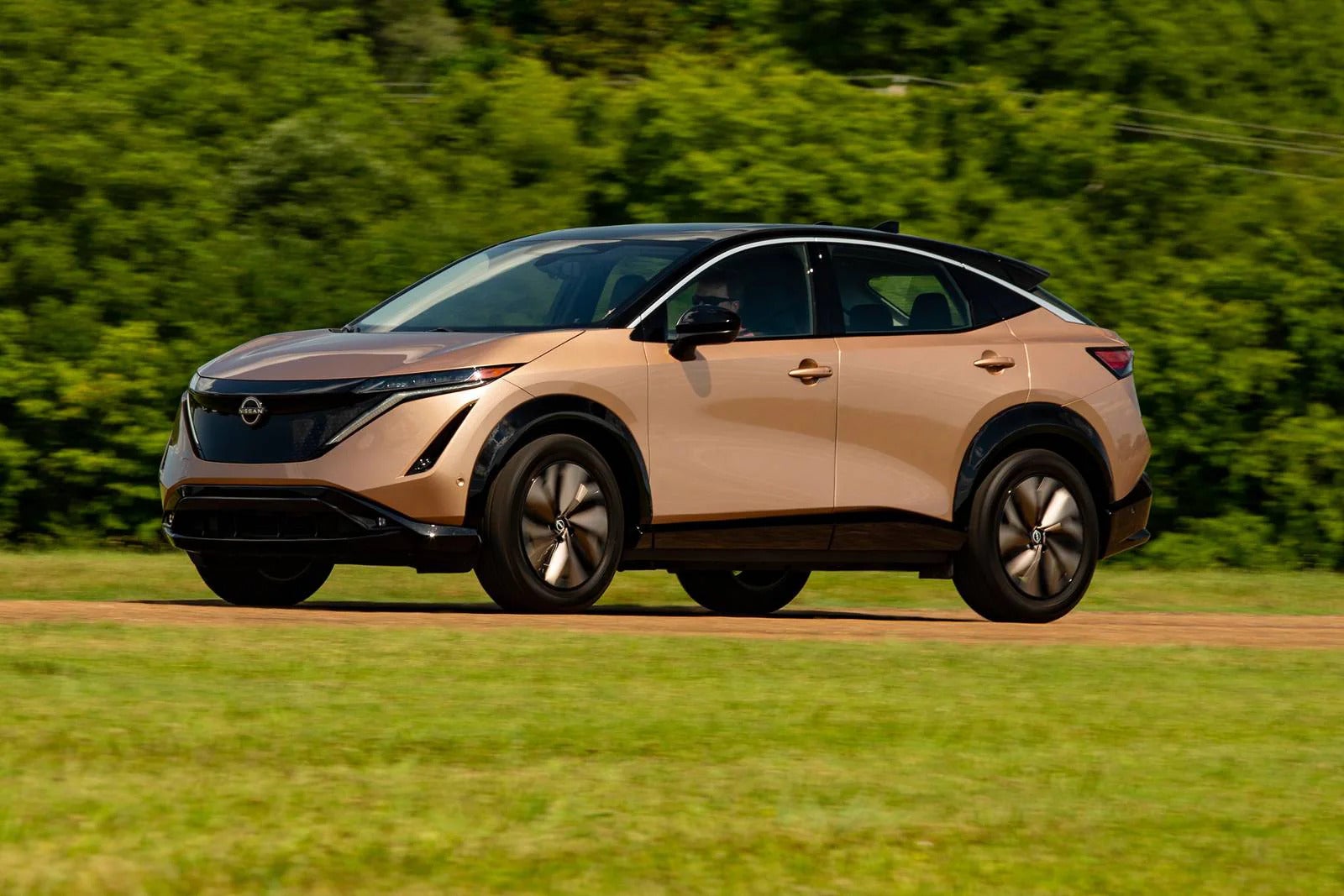 A brown car driving on the road.