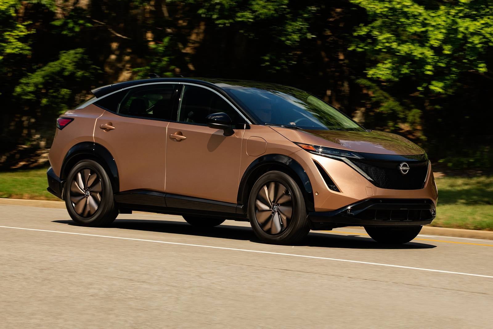 A brown car driving on the road.