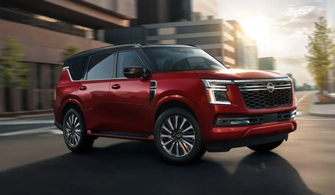 a nissan armada towing a speed boat near the mountains and a lake