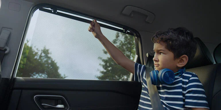 2025 Nissan Murano interior view of rear seating with child using rear door sunshades