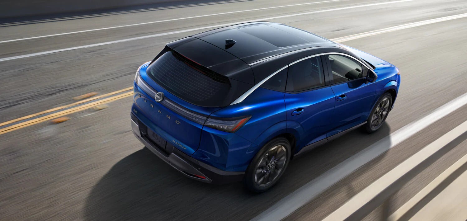 A blue car driving on the road.