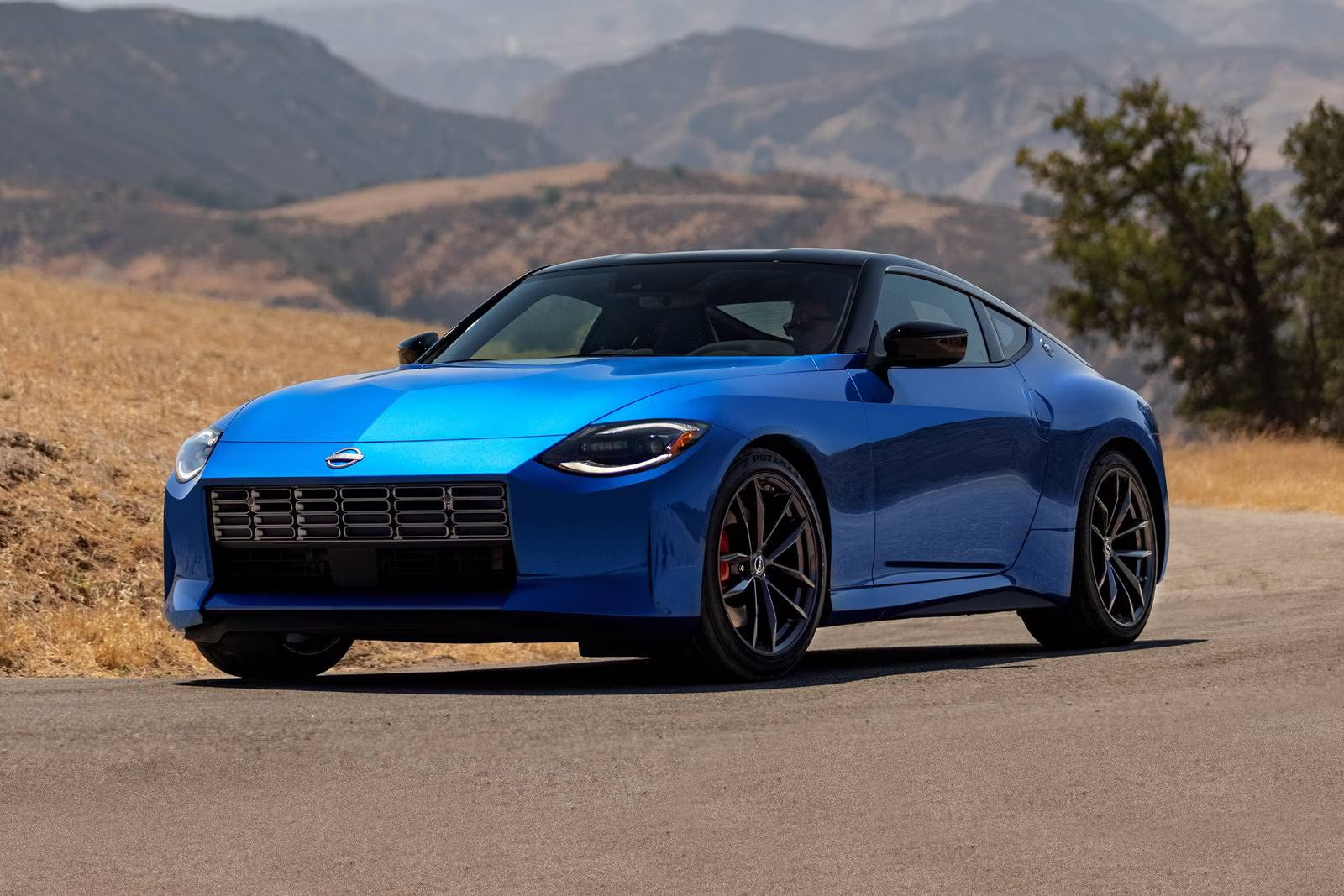 A blue car sitting in the road.