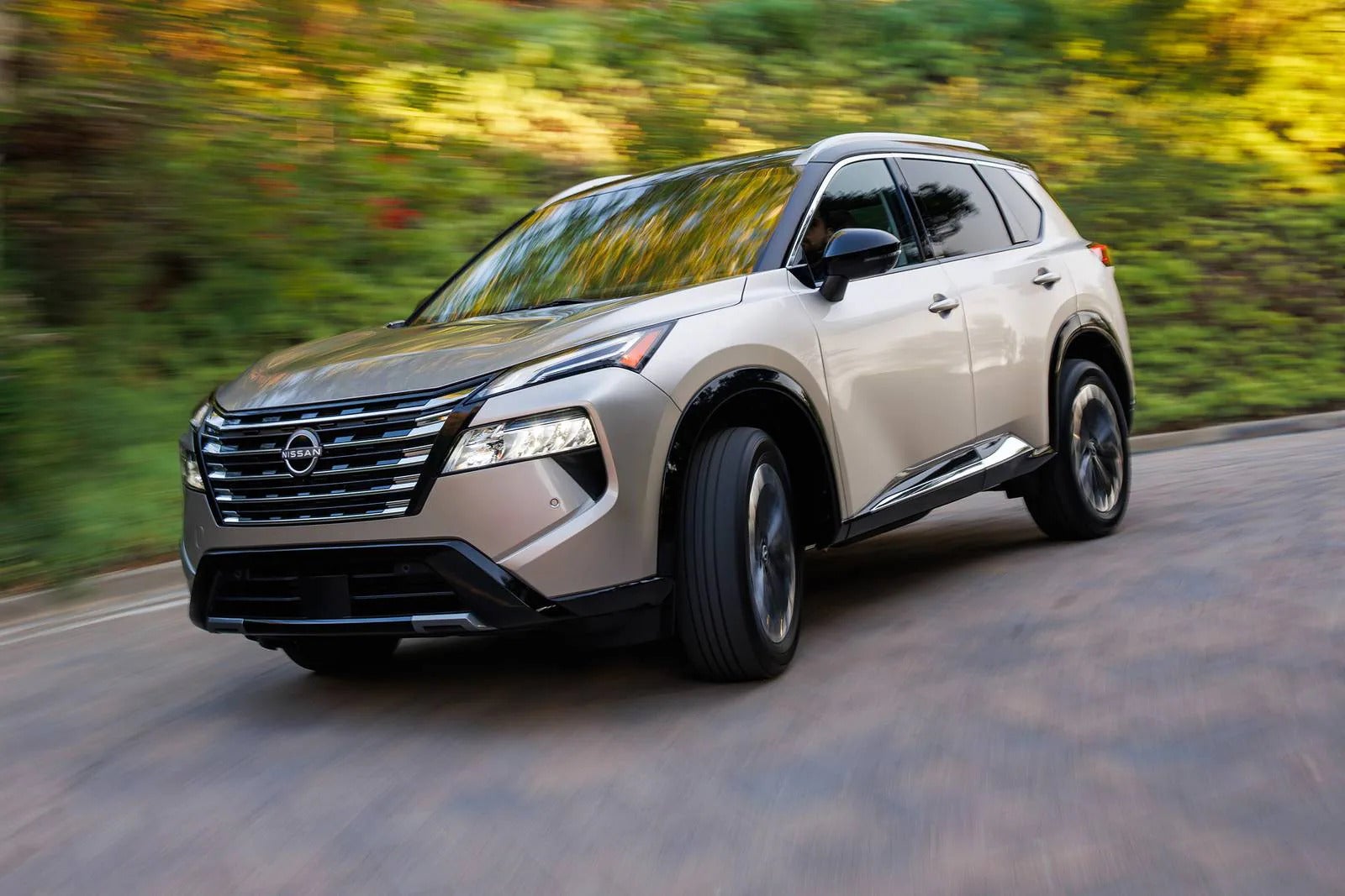 A brown suv driving on the street.