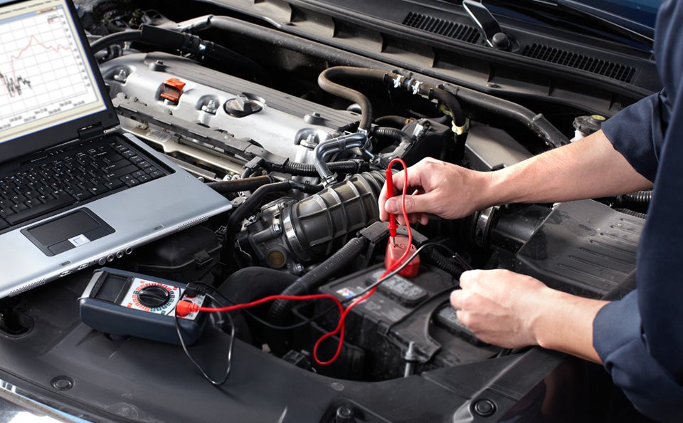 A man testing the battery in a car.