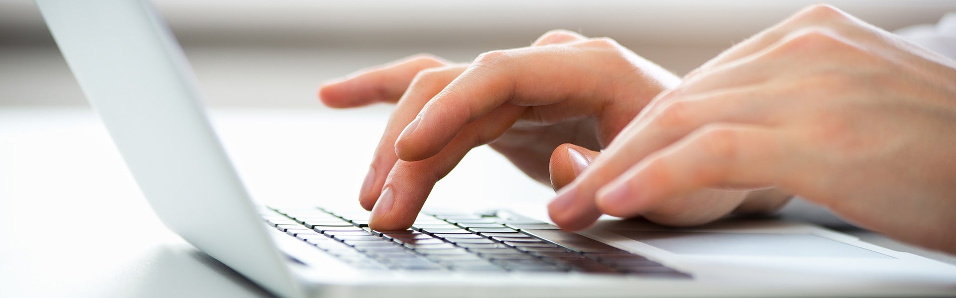 hand typing on a laptop keyboard